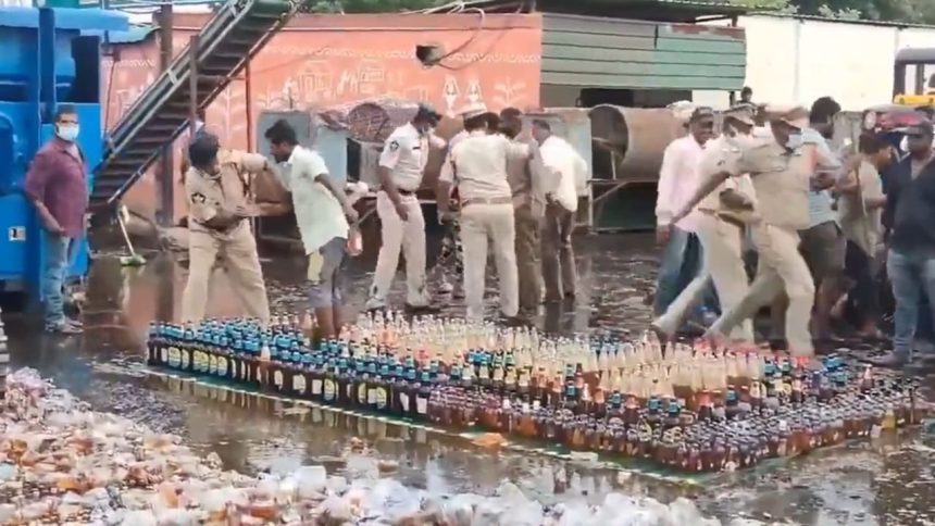 Andhra cops line up seized liquor bottles for destruction, crowd loots them | Video